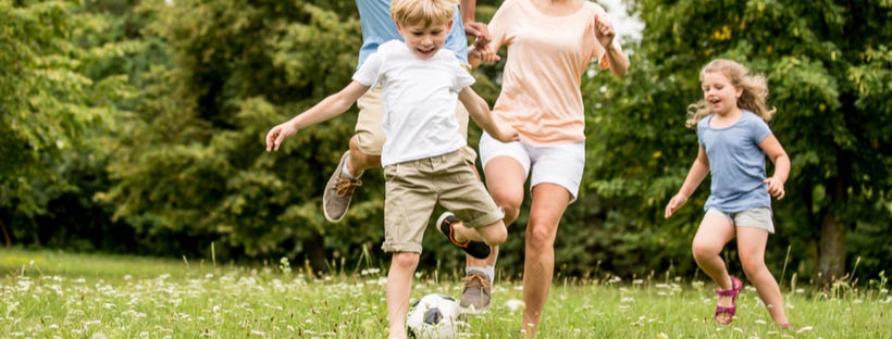 Family playing football in the garden