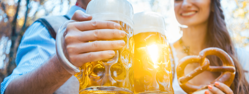 Couple holding beer mugs and pretzel